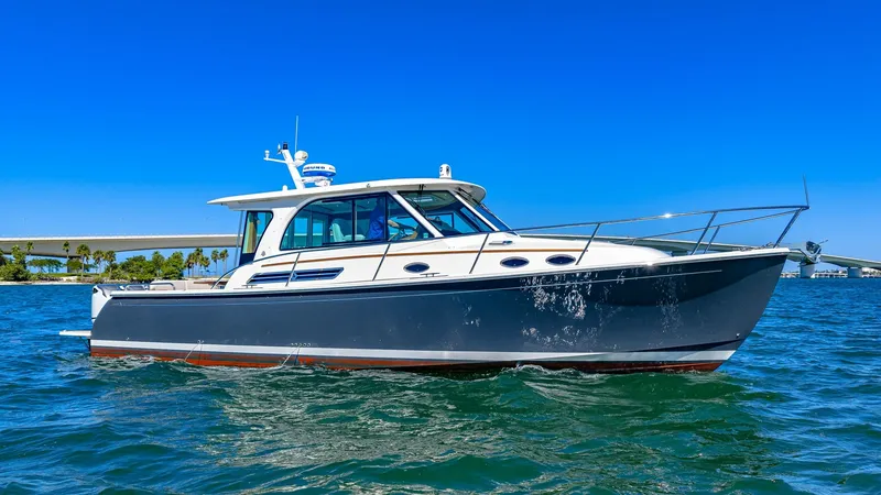 Slide: The Image of Starboard Profile of Back Cove 390 This image showcases the sleek starboard side of the 2022 Back Cove 390, 'Risk and Reward.' The yacht's elegant lines and modern design are complemented by large, tinted windows that promise panoramic views from within. The sturdy bow rail and refined hul - 8738159