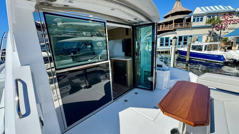 Slide: The Image of Aft Deck with Sliding Doors This aft deck on the 2024 Cruisers Yachts 50 Cantius features a sleek design with elegant sliding glass doors, seamlessly connecting the indoor and outdoor spaces. The polished table offers a perfect spot for alfresco dining or relaxing while enjoying the - 8738004