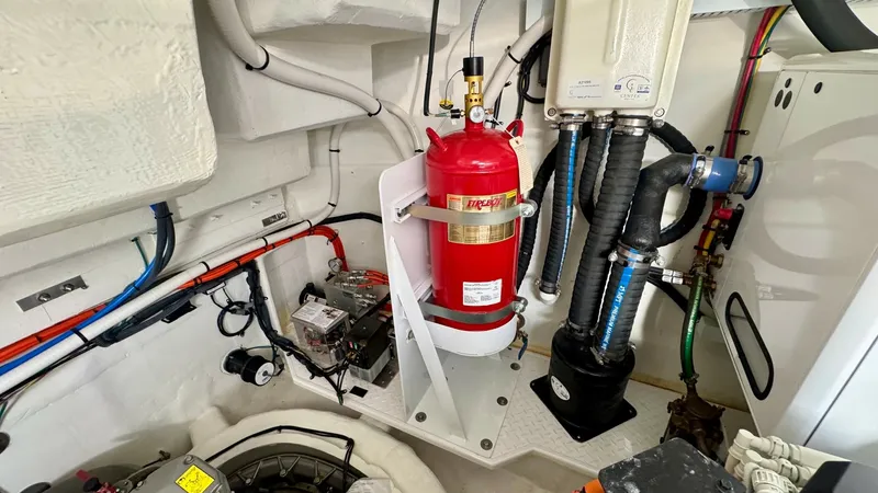 Slide: The Image of Engine Room with Fire Suppression System This image showcases the engine room of the 2024 Cruisers Yachts 50 Cantius, featuring a neatly arranged fire suppression system prominently displayed. The space is well-organized with easy access to essential components, highlighting the vessel's commitm - 8738002