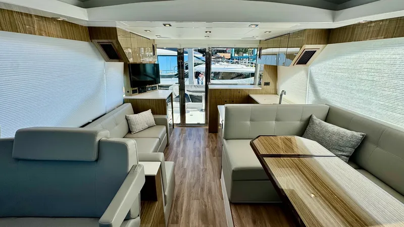 Slide: The Image of Main Salon with Panoramic Views The main salon of the 2024 Cruisers Yachts 50 Cantius offers a luxurious and spacious setting with elegant seating arrangements. The modern design features a sleek wood finish and large windows, providing ample natural light and panoramic views. A well-ap - 8737986