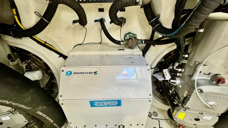 Slide: The Image of Engine Room with Seakeeper Stabilizer This image showcases the engine room of the 2024 Cruisers Yachts 50 Cantius, featuring a prominently installed Seakeeper 6 stabilizer. The clean and well-organized space highlights robust engineering, with neatly arranged piping and wiring. Designed for o - 8737999