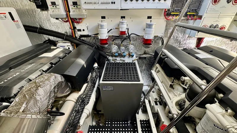 Slide: The Image of Engine Room with Twin Volvo Engines This image showcases the engine room of the 2024 Cruisers Yachts 50 Cantius, featuring twin Volvo engines for exceptional performance. The space is meticulously organized, with easy access to key systems and controls. The high-quality insulation and moder - 8737997