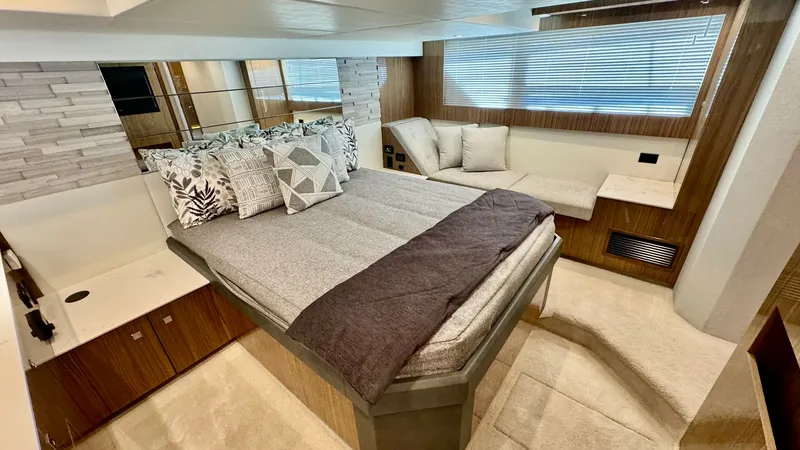 Slide: The Image of Luxurious Master Stateroom This elegant master stateroom on the 2024 Cruisers Yachts 50 Cantius features a plush queen-size bed complemented by stylish bedding. The space is enhanced by rich wood finishes and ample natural light streaming through the large windows. A comfortable se - 8737991