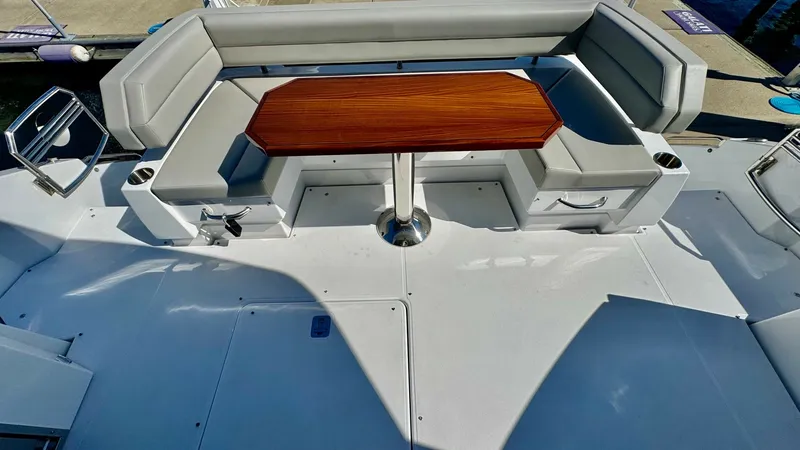 Slide: The Image of Aft Deck Seating Area The aft deck of the 2024 Cruisers Yachts 50 Cantius features a spacious U-shaped seating area with plush, light gray upholstery. A rich wooden table serves as the centerpiece, perfect for alfresco dining or entertaining. The layout offers easy access to t - 8738006