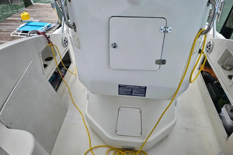 Slide: The Image of Interior view of a 1996 Hydrocat 300 X boat with storage compartments and yellow cables. - 17