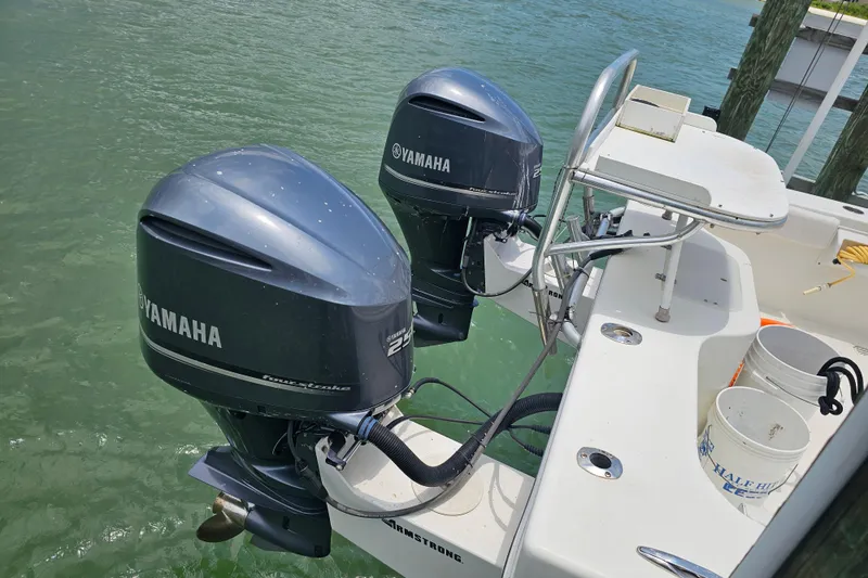 Slide: The Image of Twin Yamaha outboard motors on a 1996 Hydrocat 300 X boat, docked on calm water. - 23