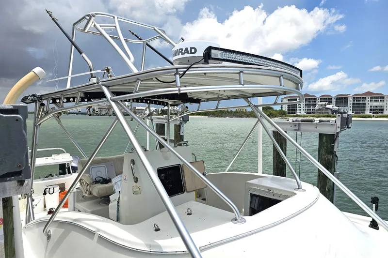 Slide: The Image of 1996 Hydrocat 300 X boat docked by waterfront buildings under a partly cloudy sky. - 24