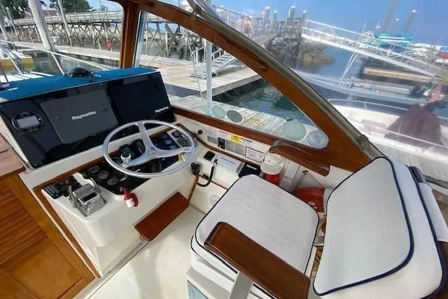 Slide: The Image of Interior of 1997 Fortier Hardtop Express boat with steering wheel and navigation equipment. - 32