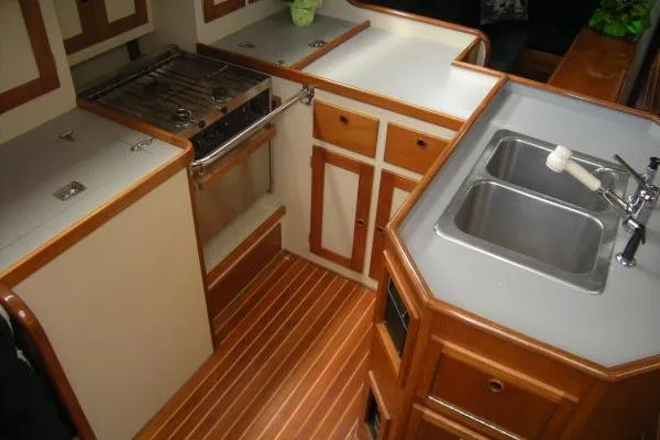 Slide: The Image of 1988 Alden 46 yacht kitchen with wood accents, dual sink, and stove. - 10