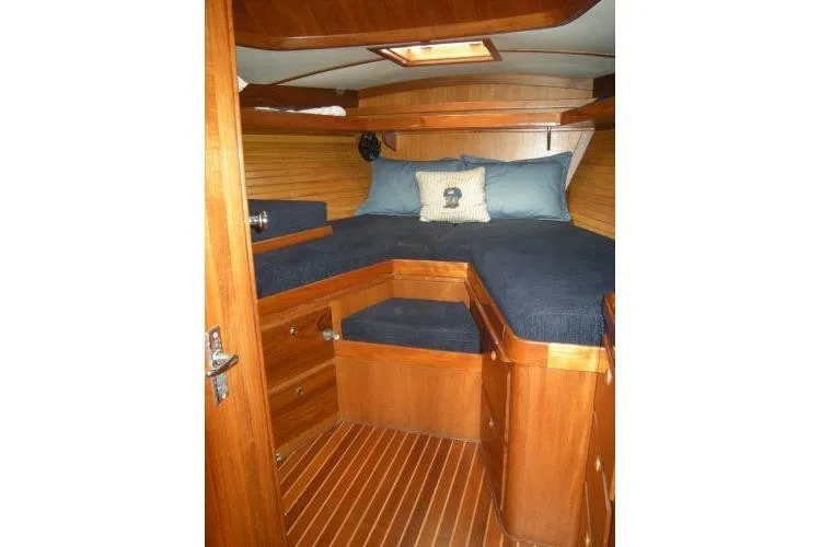 Slide: The Image of Cozy cabin interior of 1988 Alden 46 yacht with wooden finish and blue bedding. - 11