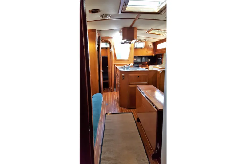 Slide: The Image of Interior of 1988 Alden 46 yacht, featuring wooden cabinetry and natural light. - 12