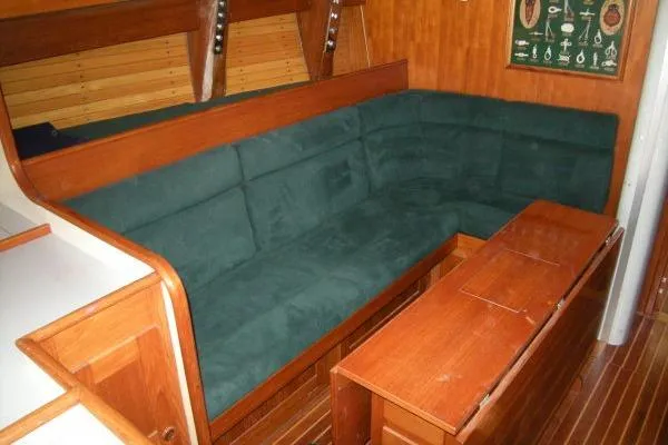 Slide: The Image of 1988 Alden 46 yacht interior with green cushioned seating and wooden furnishings. - 8