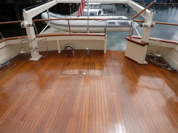 Slide: The Image of 1968 Monk 56 Flushdeck yacht with polished wooden deck and docked inflatable boat. - 10