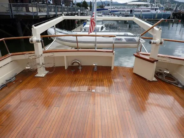 Slide: The Image of 1968 Monk 56 Flushdeck yacht with polished wooden deck and docked inflatable boat. - 11