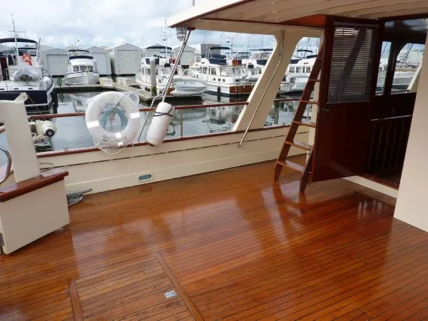 Slide: The Image of 1968 Monk 56 Flushdeck yacht with polished wooden deck, docked at marina. - 13