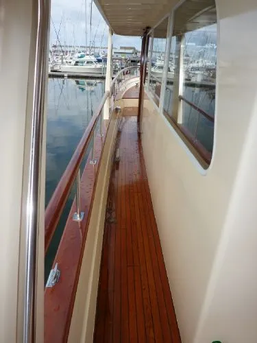 Slide: The Image of 1968 Monk 56 Flushdeck yacht with polished wooden deck and marina view. - 15