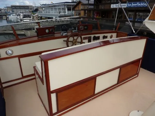 Slide: The Image of 1968 Monk 56 Flushdeck yacht helm with wooden accents at a marina. - 18