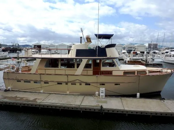 Slide: The Image of 1968 Monk 56 Flushdeck yacht docked at marina, featuring classic design and spacious deck. - 2