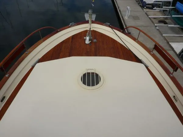 Slide: The Image of 1968 Monk 56 Flushdeck boat deck with wooden finish and porthole, docked at marina. - 20