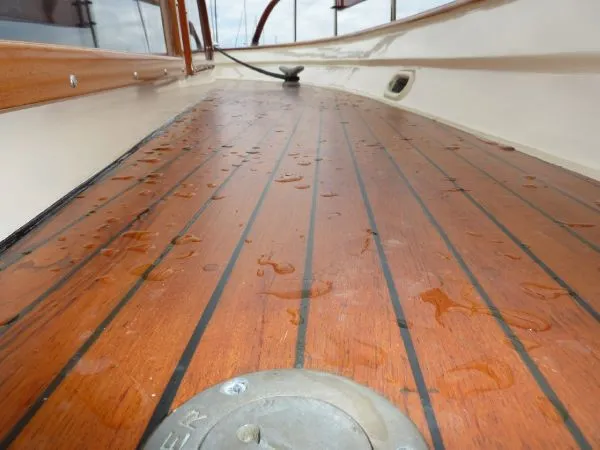 Slide: The Image of Wet teak deck of a 1968 Monk 56 Flushdeck boat, showcasing wood grain and water droplets. - 22