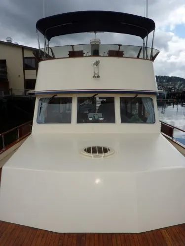 Slide: The Image of 1968 Monk 56 Flushdeck yacht with sleek design, docked at marina under cloudy sky. - 26