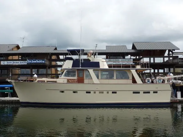 Slide: The Image of 1968 Monk 56 Flushdeck yacht docked at marina, overcast sky, wooden buildings in background. - 3