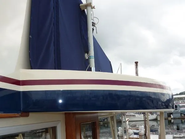 Slide: The Image of 1968 Monk 56 Flushdeck yacht with blue and white exterior, docked at a marina. - 30