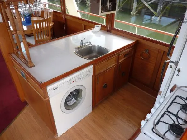 Slide: The Image of 1968 Monk 56 Flushdeck kitchen with sink, washer, and wooden cabinetry. - 37