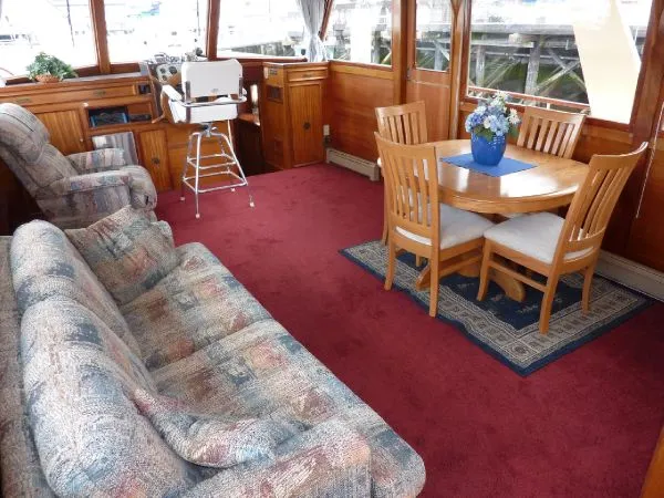 Slide: The Image of 1968 Monk 56 Flushdeck interior with red carpet, wooden dining set, and floral centerpiece. - 38