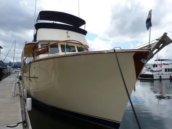Slide: The Image of 1968 Monk 56 Flushdeck yacht docked at marina under cloudy sky. - 4