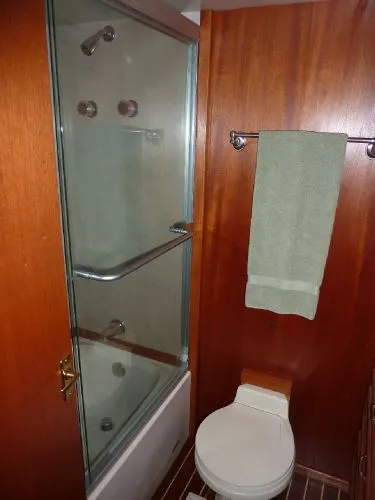 Slide: The Image of 1968 Monk 56 Flushdeck yacht bathroom with wood paneling, shower, and toilet. - 48