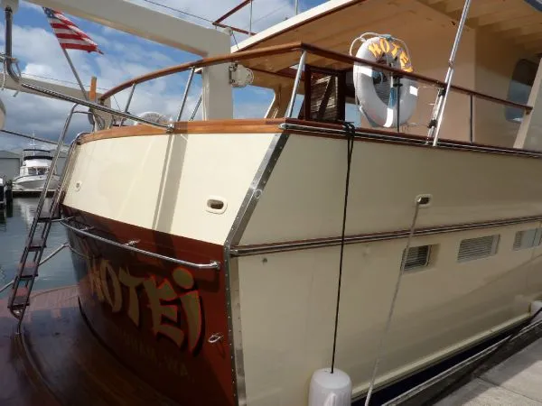 Slide: The Image of 1968 Monk 56 Flushdeck yacht docked, featuring classic design and American flag. - 9