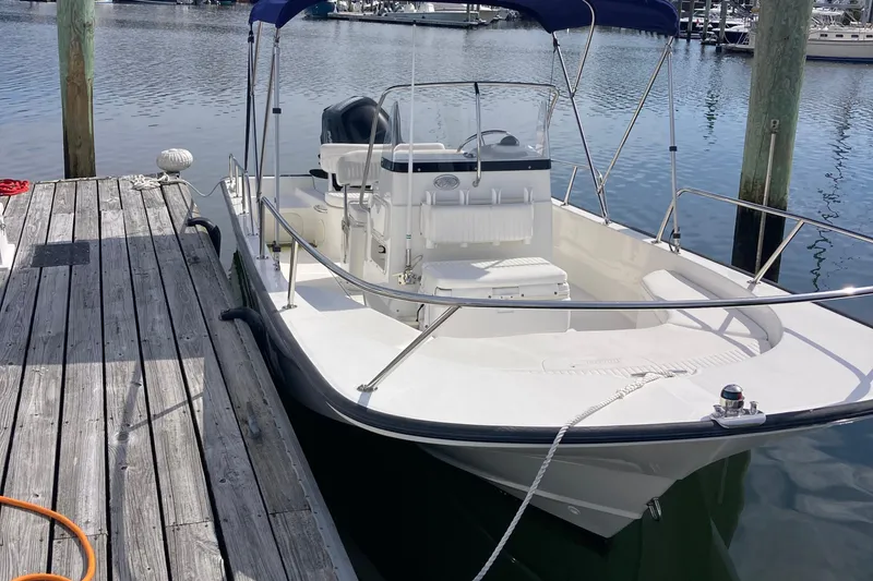 The Image of 2011 Boston Whaler 190 Montauk boat docked at marina, featuring sleek design and spacious deck. - 0