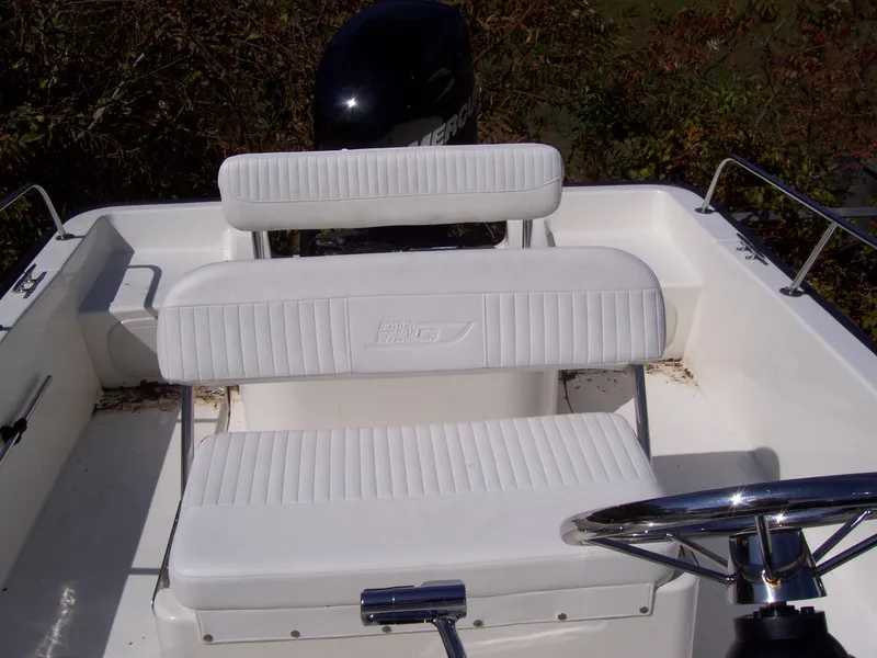 Slide: The Image of 2011 Boston Whaler 190 Montauk boat interior with white seating and steering wheel. - 11