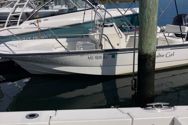 Slide: The Image of 2011 Boston Whaler 190 Montauk boat docked in marina, side view. - 2