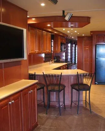 Slide: The Image of Modern kitchen with wooden cabinets, bar stools, and a flat-screen TV; Sharpe Makena Share 5, 2006. - 2