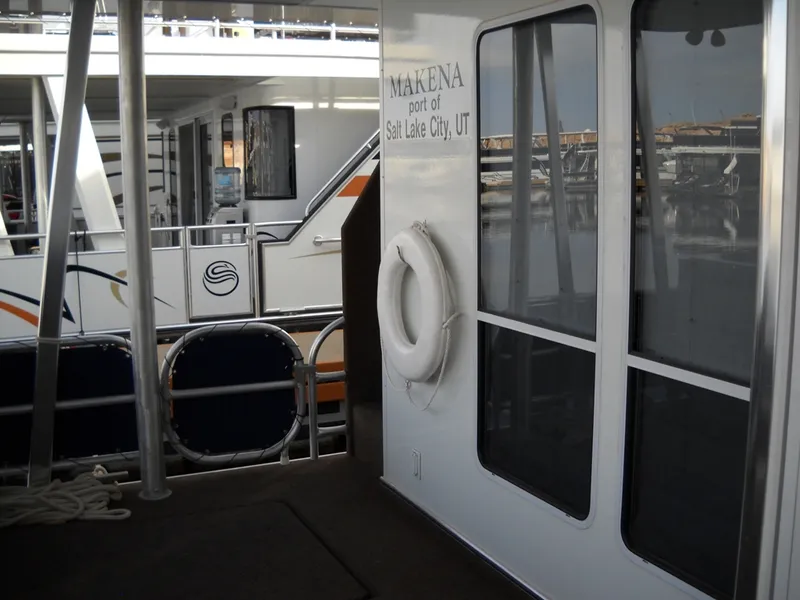 Slide: The Image of Houseboat docked at marina, labeled "Makena" from Salt Lake City, UT, with life preserver. - 7