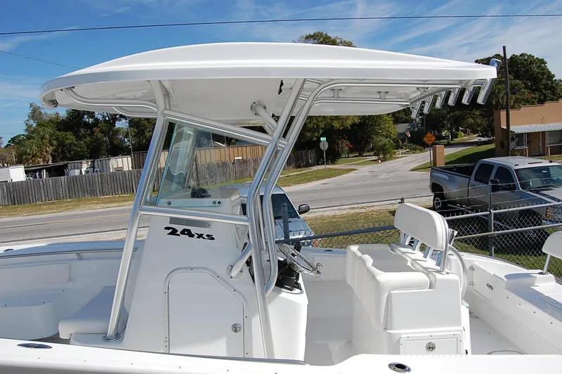 Slide: The Image of 2025 Cape Horn 27 XS boat with T-top and seating, docked near residential area. - 10