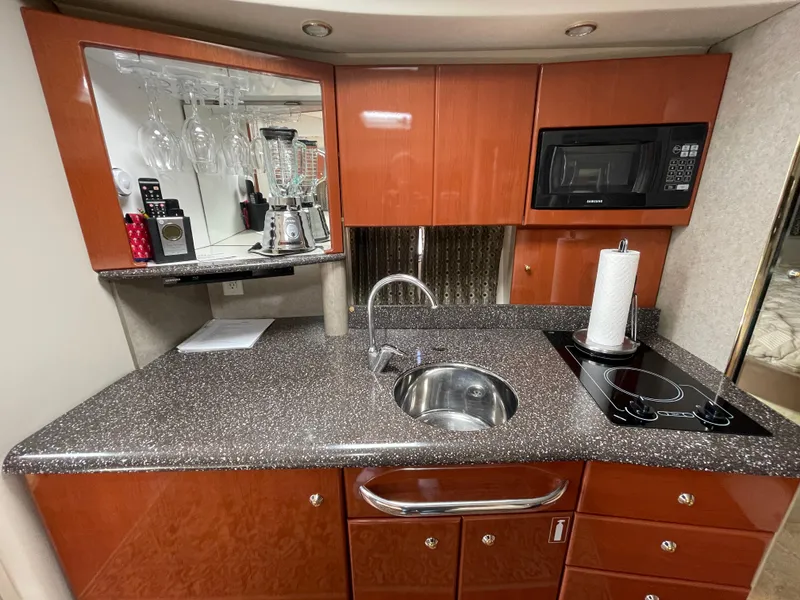 Slide: The Image of 2004 Formula 37 PC yacht kitchen with wood cabinets, sink, microwave, and stovetop. - 8