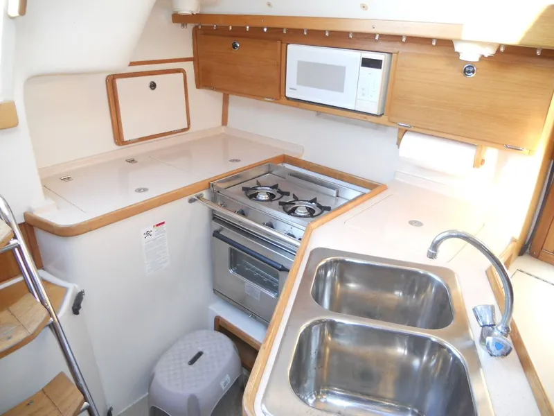 Slide: The Image of 1999 Catalina 320 yacht kitchen area with stove and sink. - 10