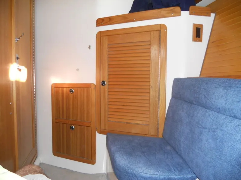 Slide: The Image of Interior of a 1999 Catalina 320 yacht with wooden cabinets and blue upholstery. - 13