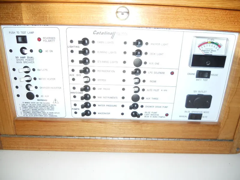 Slide: The Image of Control panel of a 1999 Catalina 320 boat with switches and gauges. - 14