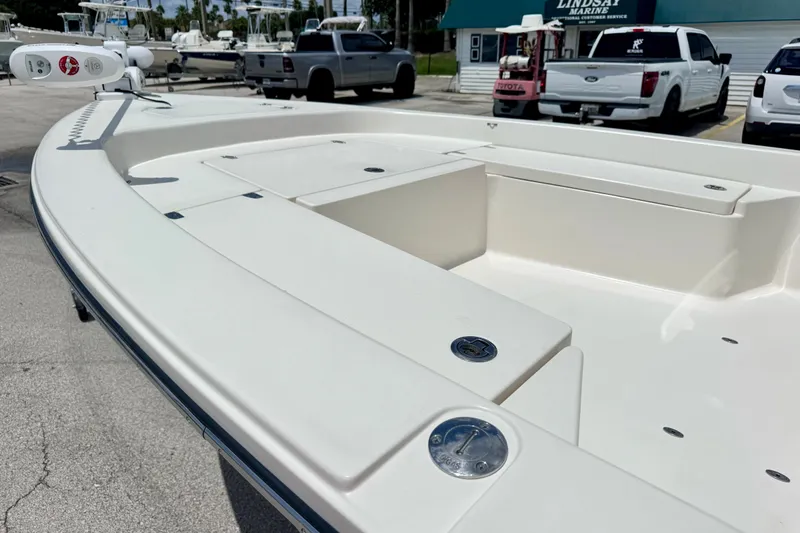 Slide: The Image of 2012 Pathfinder 2200 TRS boat deck, white finish, parked near trucks and marine service. - 12