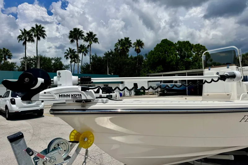 Slide: The Image of 2012 Pathfinder 2200 TRS boat with Minn Kota Terrova motor, parked under cloudy sky. - 11