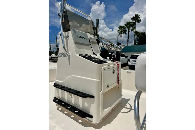 Slide: The Image of 2012 Pathfinder 2200 TRS boat console with Garmin navigation, under a partly cloudy sky. - 14