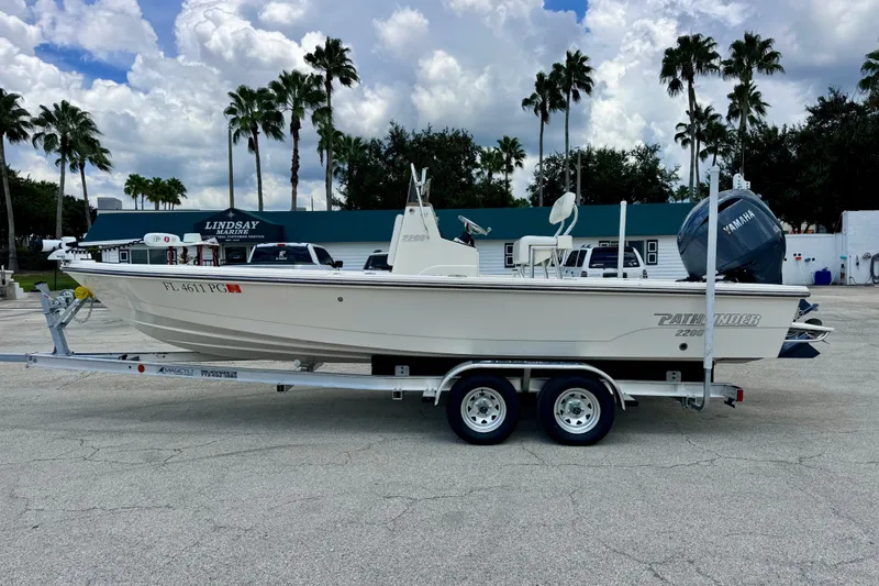 Slide: The Image of 2012 Pathfinder 2200 TRS boat on trailer, parked at Lindsay Marine, under cloudy sky. - 5
