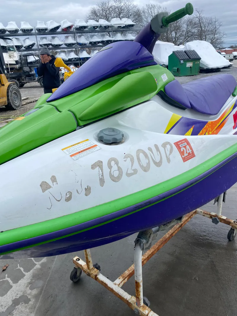 Slide: The Image of 1996 Kawasaki ZXI 900 jet ski in green and purple on a stand. - 8