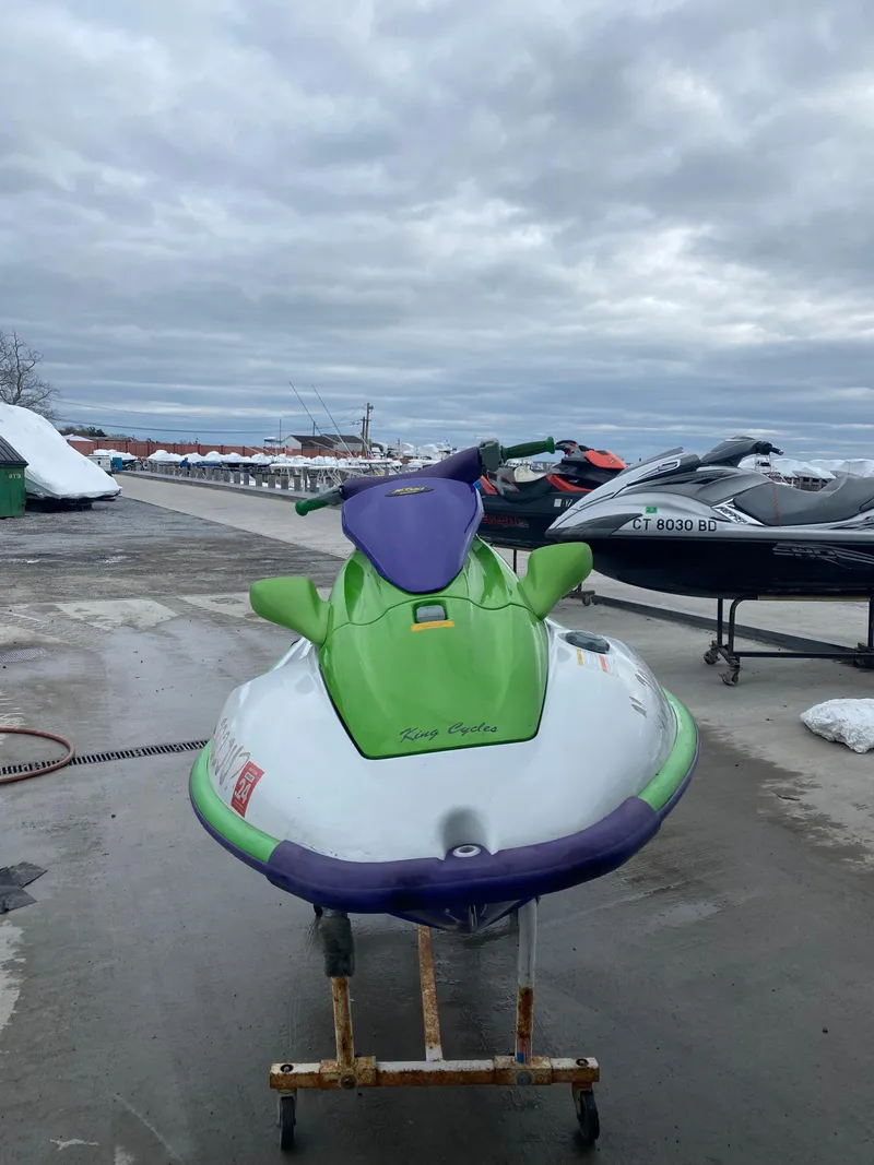 Slide: The Image of 1996 Kawasaki ZXI 900 jet ski in green and purple, parked on a dock. - 9