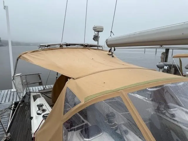 Slide: The Image of 2003 Wauquiez Centurion 45s sailboat with tan canopy docked on a foggy day. - 13