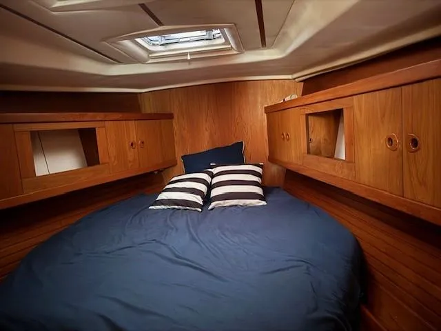 Slide: The Image of Cozy cabin interior of 2003 Wauquiez Centurion 45s with wooden finish and blue bedding. - 37